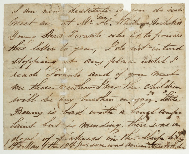 Handwritten letter in black ink on brown and yellowing paper, with brown staining and white scuff marks.