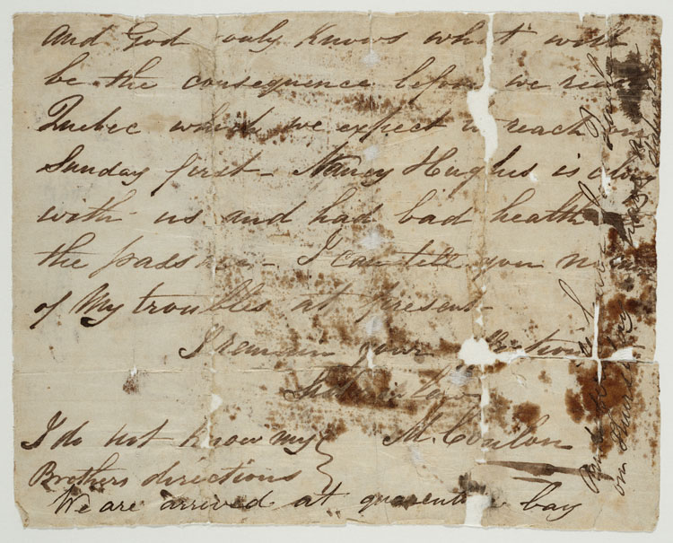 Une lettre écrite à la main et à l’encre noire, sur du papier qui a jauni, maculée de marques blanches et de taches brunes.