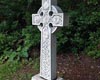 Vue diagonale du monument de la croix celtique aux Irlandais du Canal Rideau. Feuillage verdoyant à l’arrière-plan.