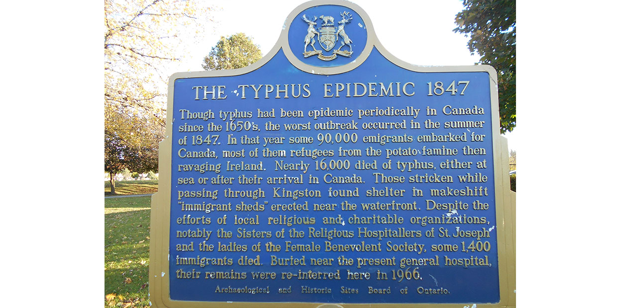 Plaque historique de couleur bleue sur laquelle sont rédigées des inscriptions en caractères dorés à propos de l’épidémie de typhus de 1847.