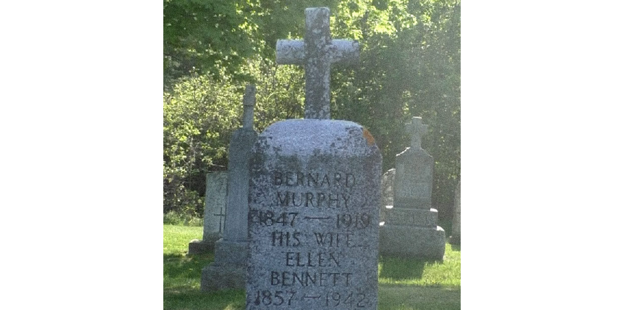 Close up photograph of headstone, inscribed on which is written: Bernard Murphy. 1847-1919. His Wife Ellen Bennett. 1857-1942. Murphy is inscribed on the base of the grave stone.