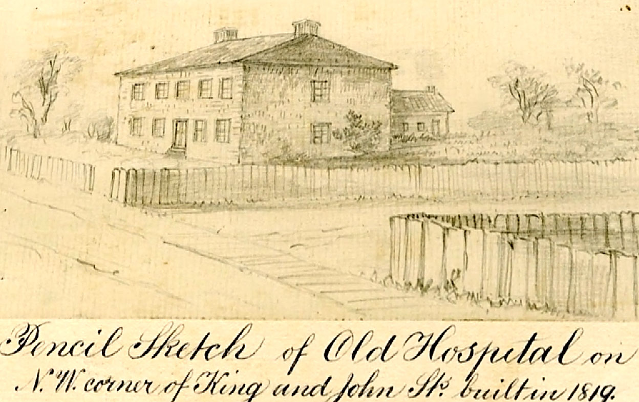 Yellowing black and white illustration of profile two storey building with windows on both floors and sloped roof in background, picket fence surrounding it and wooden walkway in foreground. Written on illustration: Pencil Sketch of Old Hospital on N.W. Corner of King and John Sts. Built in 1819.