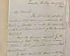Handwritten letter on white paper folding at margins on grey backdrop.