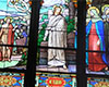 Stained glass window with McElderry inscribed bottom right. Bearded man in white robes above inscription, with woman in red dress and blue shawl on right.