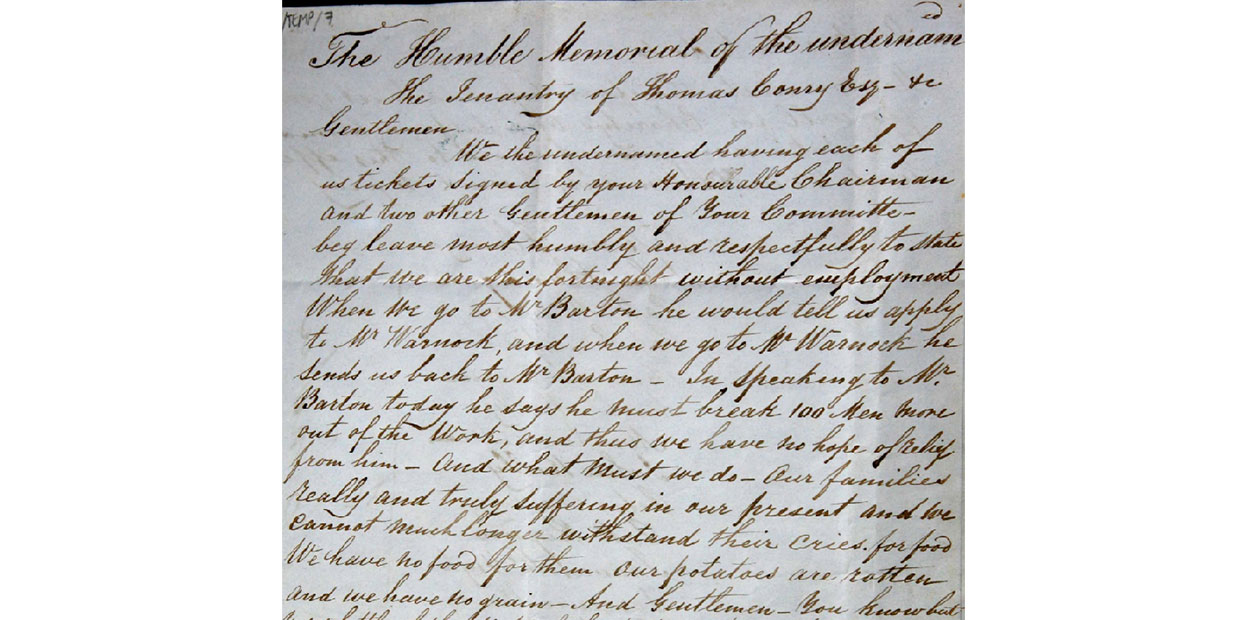 Handwritten document in dark ink on grey paper. The first line larger than the rest, and it reads: The Humble Memorial of the Undersigned