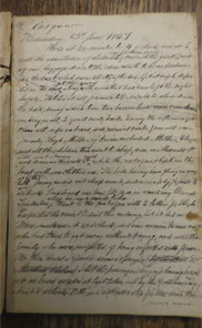 Handwritten page of diary. Surface of brown table visible in top and bottom of image.